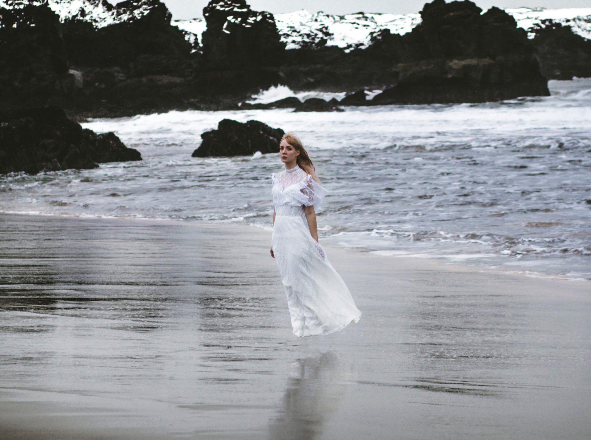 le surf les vagues les rochers la jeune fille la robe le vent