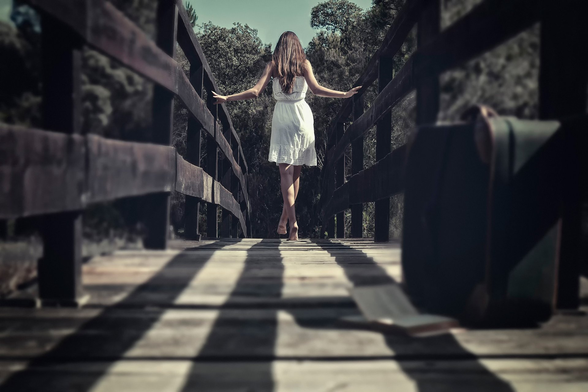 ponte valigia ragazza a piedi nudi vestito bokeh