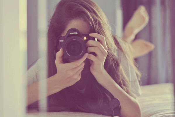 La ragazza con la macchina fotografica si riflette nello specchio