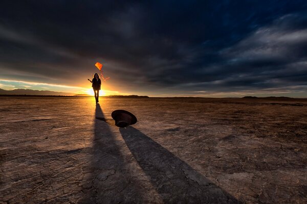 Ragazza con un aquilone nel deserto