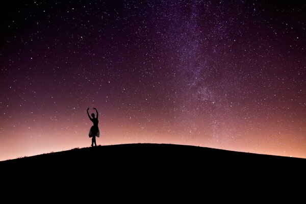 Ballerina dancing on the background of the starry sky