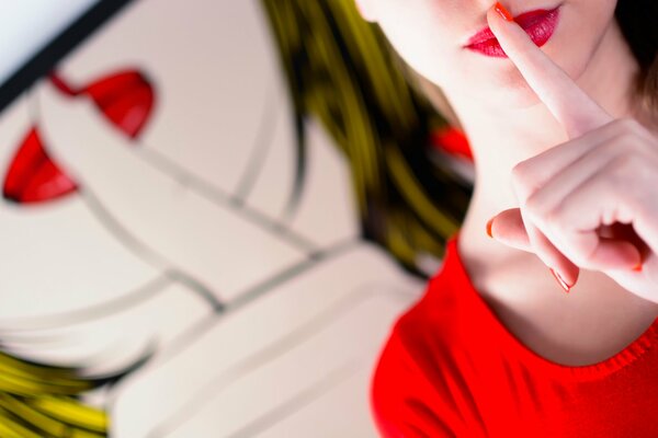 Dziewczyna w Czerwieni przykłada palec do ust