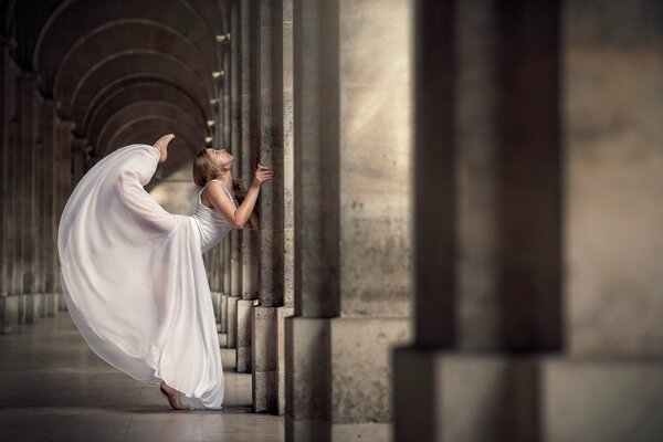 Graceful swing of a ballerina in a white dress
