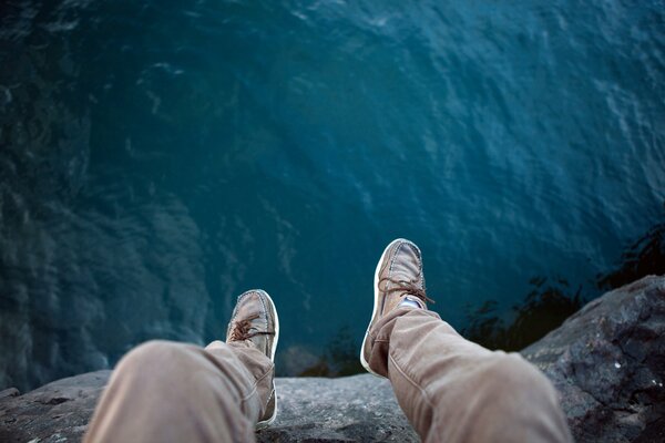 Feet boots hanging off the cliff