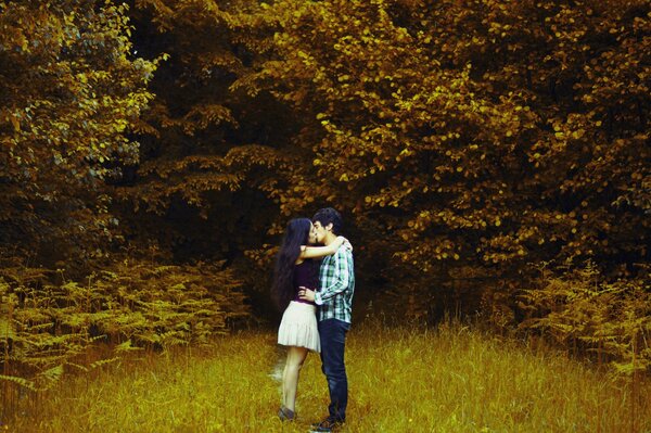 Ein Kerl und ein Mädchen umarmen sich im Herbstwald