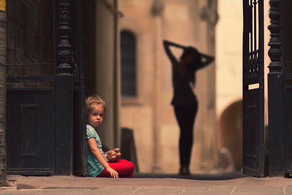 A little girl is sitting on the ground