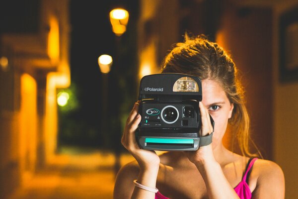 Beautiful girl with a camera on the street