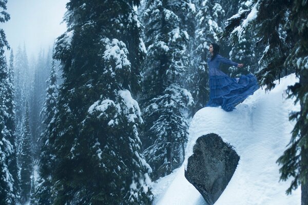 Chica en el fondo de los abetos en la nieve