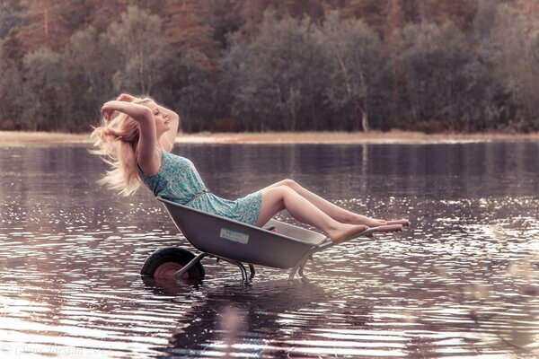 A girl in the water on an unusual wheelbarrow