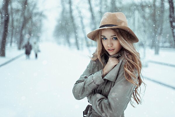 Una calle Nevada en Rusia, en primer plano una chica con un abrigo y un sombrero