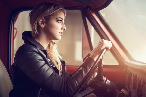 La jeune fille avec des cheveux blonds dans la voiture