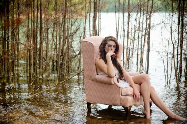 La jeune fille dans un fauteuil au fond de la forêt