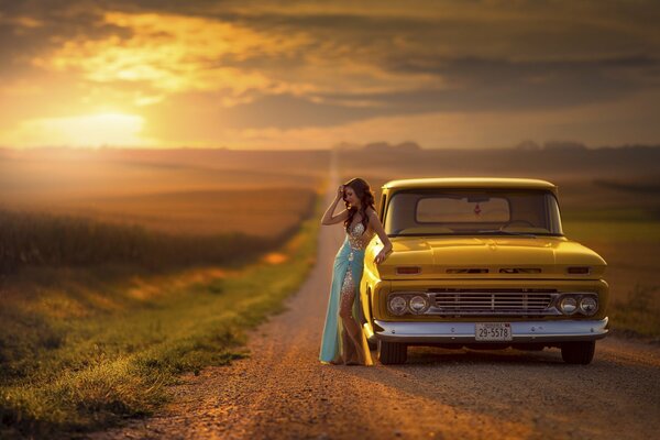 A girl near a yellow car on the road