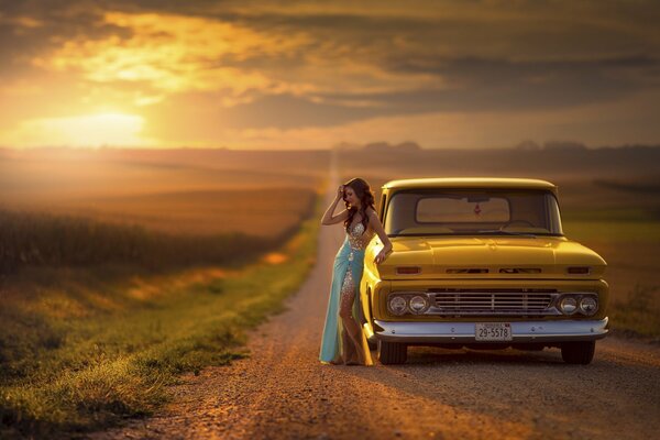 Девушка около желтой машины на дороге