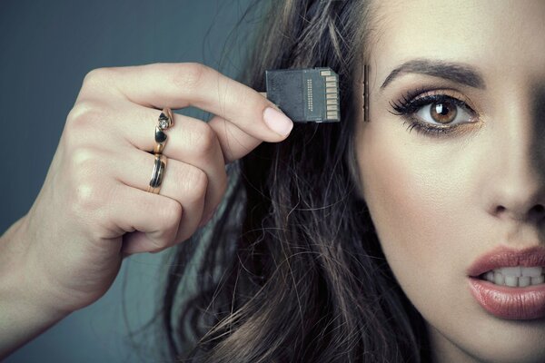 The girl holds a memory card in her hand