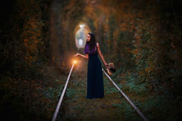 Chica al atardecer caminando en el ferrocarril