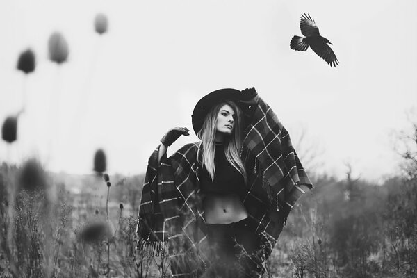 The color is gray of nature a crow is flying nearby a girl is standing