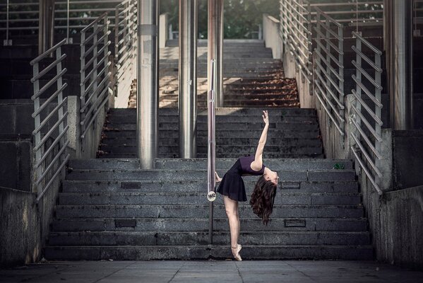 A girl dances against the background of steps