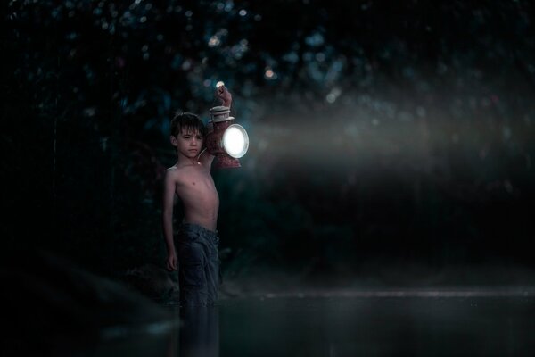 A boy in the dark with a lantern in his hands