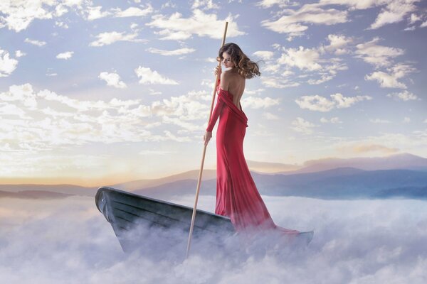 Hermosa foto de una chica con un vestido rojo en un barco en la niebla