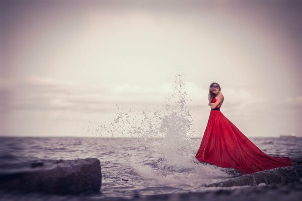 Mädchen im roten Kleid am Meer