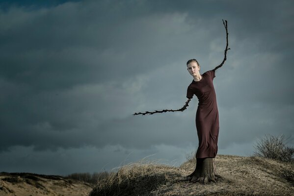 La jeune fille avec des branches à la place des mains