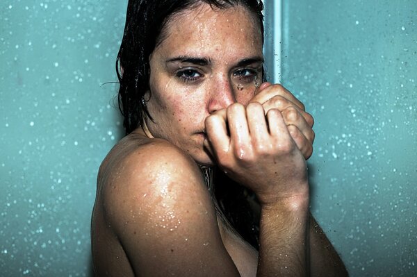Девушка с темными волосами стоит под душем
