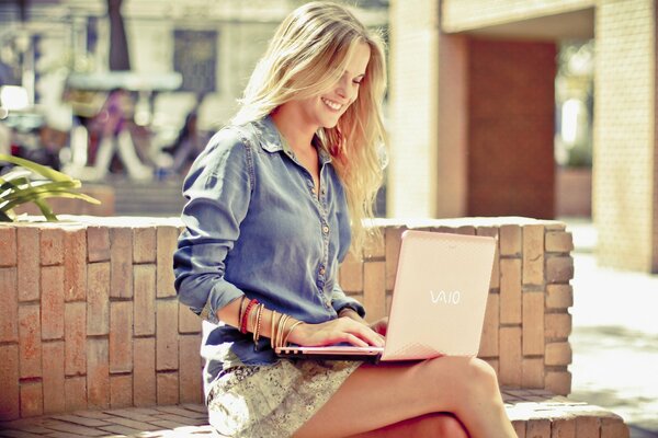 Blonde girl working at a laptop