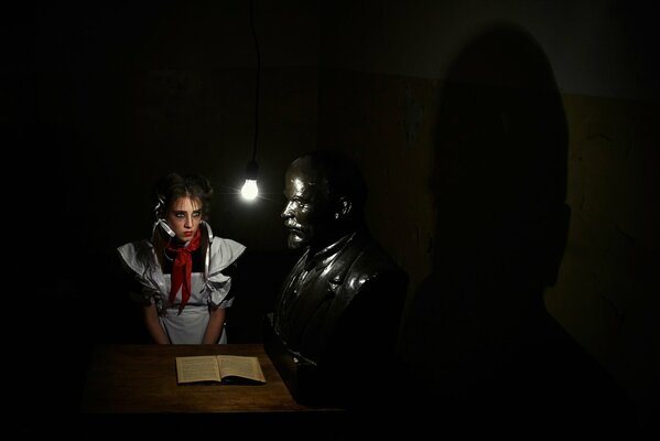 A schoolgirl. Bust of Lenin. Book