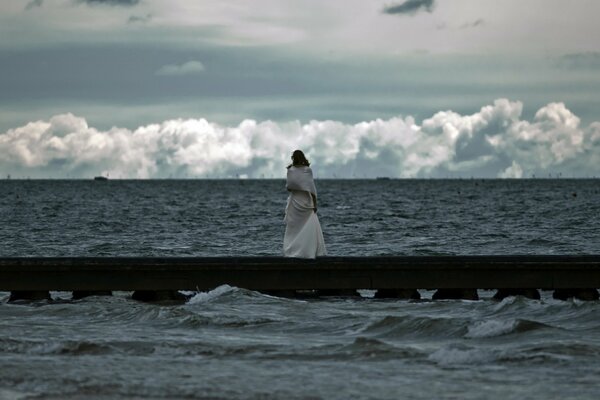 Mädchen schaut auf das tobende Meer