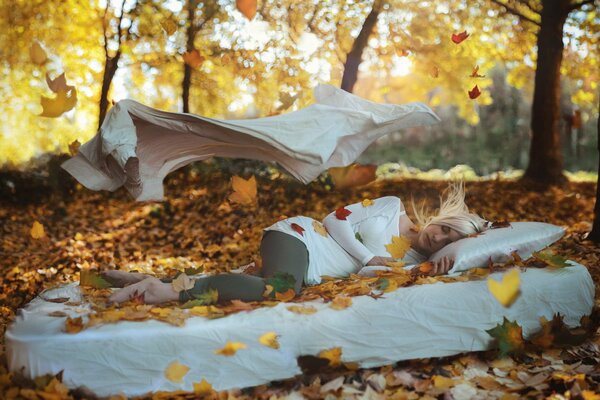 Ragazza che dorme su bianco nella foresta