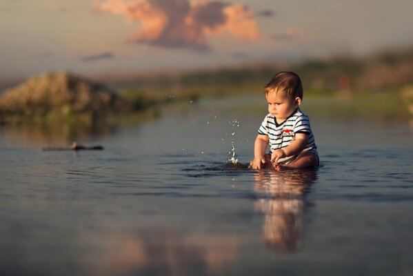 The boy splashes in the water