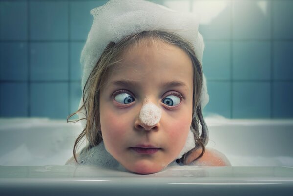 La fille à nettoyer dans un bain avec de la mousse
