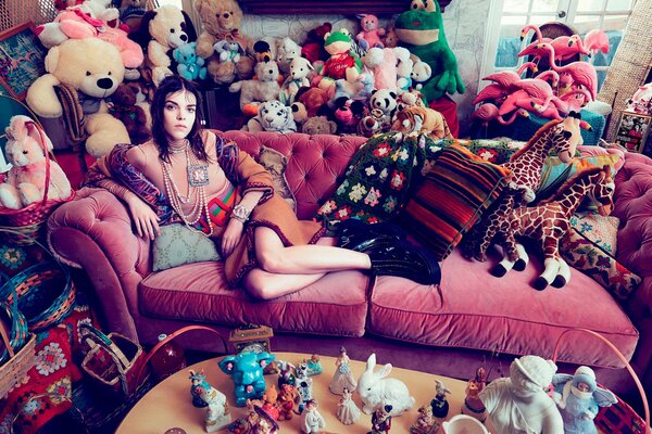 Megan Collison is sitting on the couch among the toys