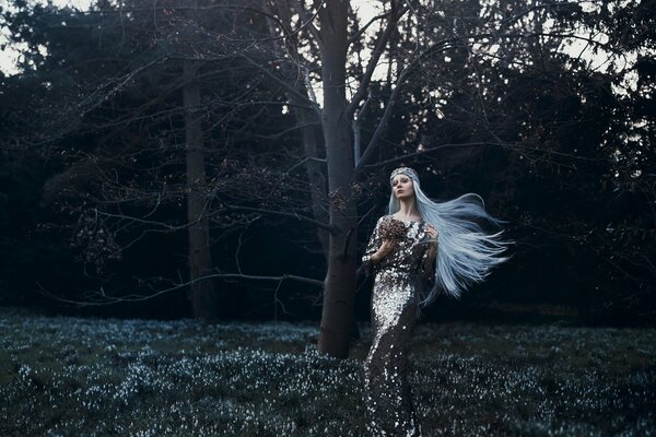 Schönes Foto eines Mädchens in einem Kleid mit weißen Haaren im Wald