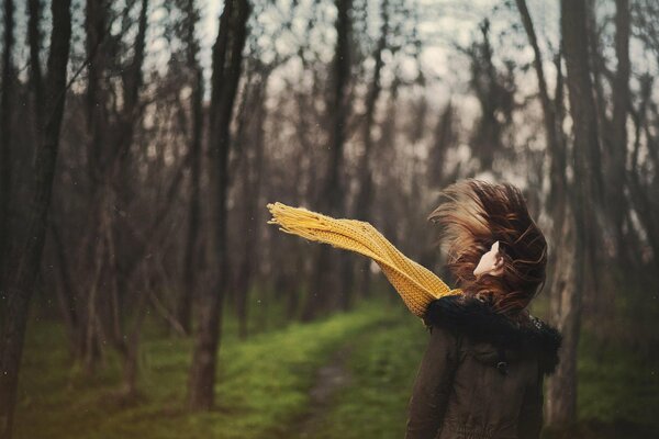 A girl in the forest in a yellow scarf