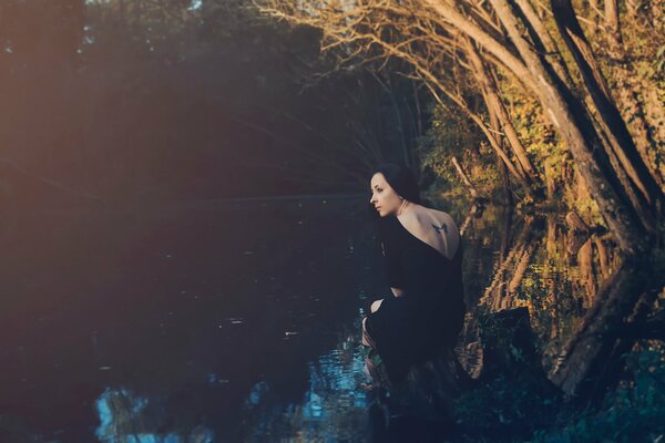 Photo of a girl with a tattoo on the background of nature