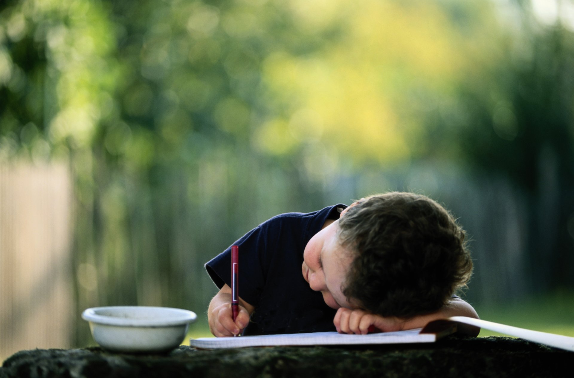 ragazzo bambino penna matita scrive disegnare album immagine ciotola tazza sfondo sfocato