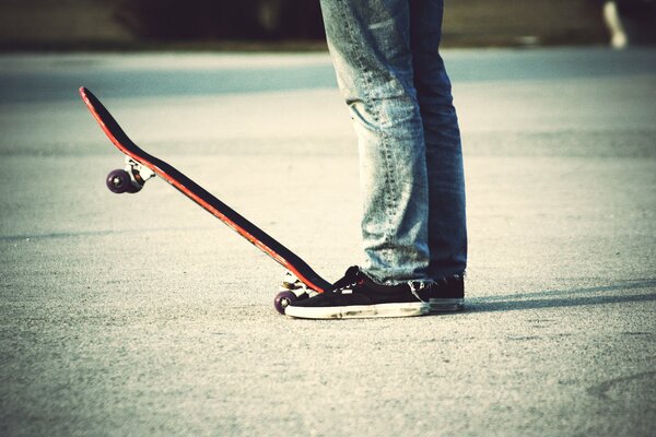 Mann in Jeans auf einem Skateboard