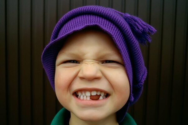 Garçon dans un chapeau violet et sans dents