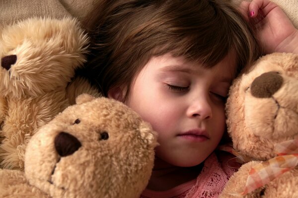 Маленькая девочка, сладко спит в окружении своих любимых игрушек, плюшевых мишек