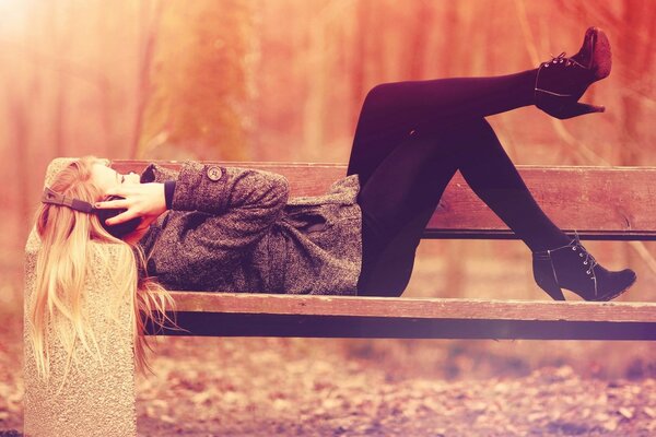 A girl lying on a park bench