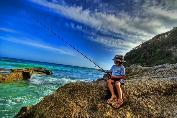 Pesca en el mar. Niño con caña de pescar