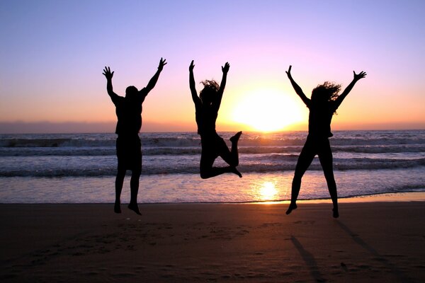 Tres chicas tomando fotos al atardecer