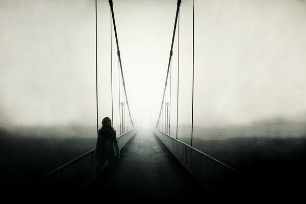 A man stands in the fog on the bridge