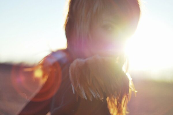 Foto de una hermosa chica en el fondo de los rayos del sol