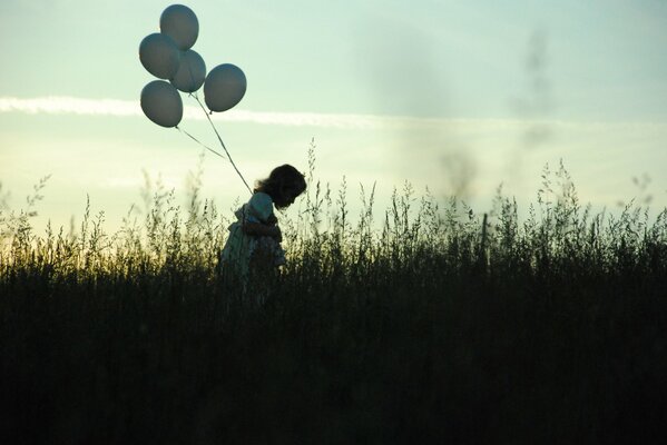 Девочка с шарик и на фоне вечернего неба