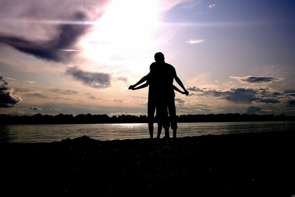 Pareja enamorada al atardecer junto al lago