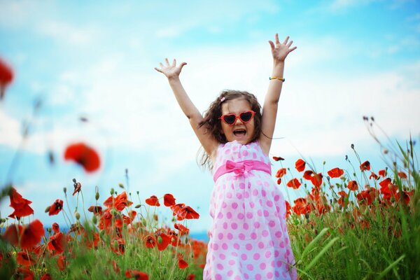 A girl with heart-shaped glasses on a poppy field