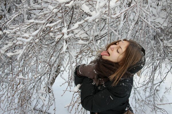 Fille attrape la neige avec la langue